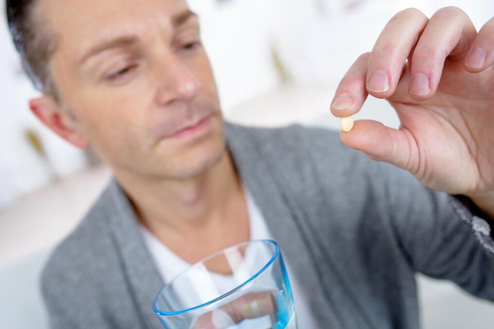 Un homme boit des pilules pour augmenter l'efficacité